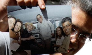 Ex-cie-president Juja toont de foto met hem en Fidel Castro op weg in het busje naar Hotel Nacional; rechts Daliah Sotto del Valle